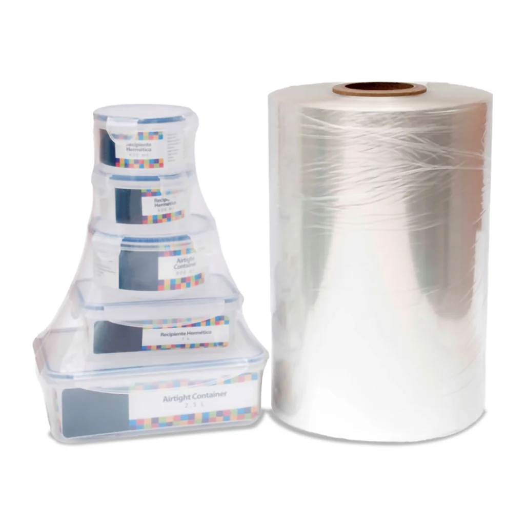 Rollo de polietileno termoencogible junto a pila de bandejas empacadas